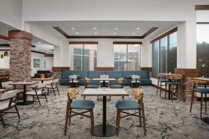 a lobby with tables and chairs and windows at Hilton Garden Inn Fort Worth Medical Center in Fort Worth