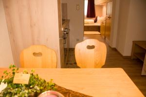 dwa drewniane krzesła w pokoju ze stołem w obiekcie Haus Astoria w mieście St. Leonhard im Pitztal +37 zdjęć