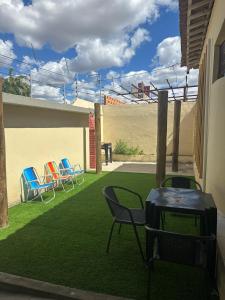 a patio with chairs and a grill on the grass at Pousada Nova Betânia in Mossoró