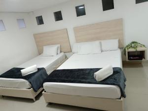 a bedroom with two beds and a couch at Hotel pasarela real cali in Cali