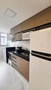 a kitchen with white appliances and a white refrigerator at Apê Morabeza in Vila Velha