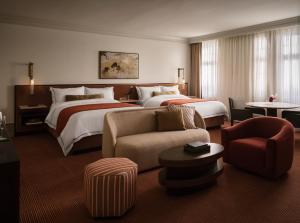a hotel room with two beds and a couch at The Huntington Hotel in San Francisco