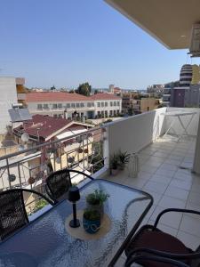 a balcony with a table and chairs on a roof at J&J spacious balcony apartment in Preveza +13 photos