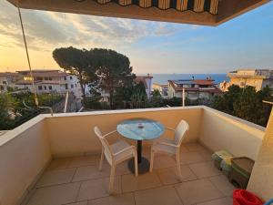 a balcony with a table and two chairs and the ocean at ele&gio accomodation - Sea View in Tropea