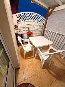 a white table and chairs on a balcony at GITE LE FILAO in Le Lorrain