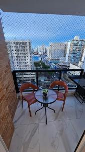 a balcony with a table and chairs and a view of a city at Apê Morabeza in Vila Velha