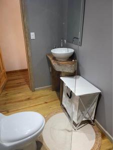 a bathroom with a white toilet and a sink at Jonathans Cabins in Utila