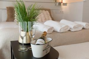 a table with a bottle of champagne and glasses on a bed at Casita Romántica con Suite y Bañera en la Sierra "Colladito de Alce" in Collado Hermoso
