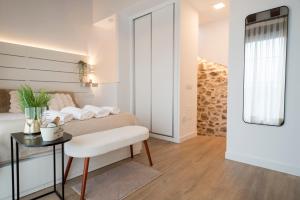 a bedroom with a bed and a table with a chair at Casita Romántica con Suite y Bañera en la Sierra "Colladito de Alce" in Collado Hermoso