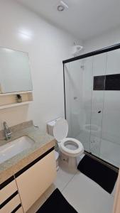 a bathroom with a toilet and a glass shower at Apê Morabeza in Vila Velha +16 photos