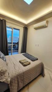 a bedroom with a bed and a large window at Apê Morabeza in Vila Velha