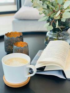 a cup of coffee and a book on a table at Spacious Mountain Cabin With View In Nissedal in Treungen