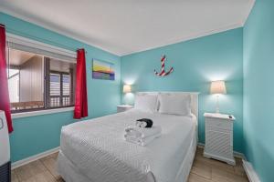 a bedroom with a bed with a doll on it at Beach, Please! Oceanfront, Balcony & Sunrise Views in North Topsail Beach