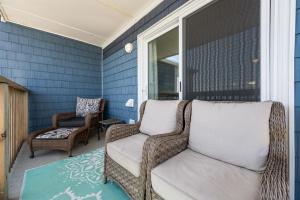 a porch with a wicker chair and a window at Beach, Please! Oceanfront, Balcony & Sunrise Views in North Topsail Beach