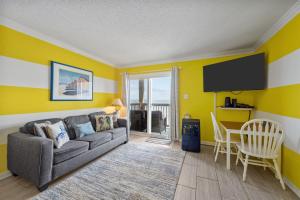 a living room with a couch and a table at Beach, Please! Oceanfront, Balcony & Sunrise Views in North Topsail Beach