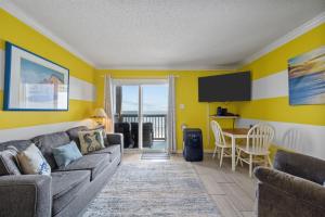 a living room with a couch and a table at Beach, Please! Oceanfront, Balcony & Sunrise Views in North Topsail Beach