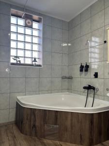 a bath tub in a bathroom with a window at Pura Vida Apartment in Mostar +12 photos