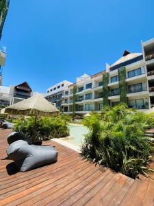 a wooden deck with an umbrella and a building at Bakal Luxury condos in Tulum
