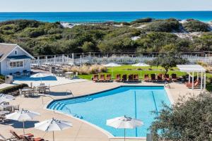 a view of a pool with umbrellas and the ocean at 13 Madaket Way in Watersound Beach