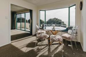 a dining room with a table and chairs on a balcony at Oceanfront Retreat - Beach Access - 2BR Bell Block in New Plymouth