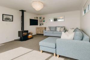 a living room with a couch and a fireplace at Oceanfront Retreat - Beach Access - 2BR Bell Block in New Plymouth