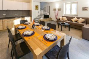 a dining room and living room with a table and chairs at Lenno Dolcelago in Lenno