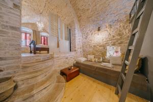 a room with a bed in a stone wall at Alternative Medieval Villa in Kalamoti