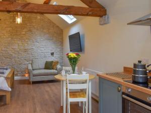 a kitchen and living room with a table and a chair at The Loft - Uk50284 in Earl Sterndale