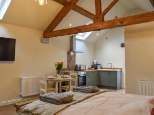 a bedroom with a large bed and a kitchen at The Loft - Uk50284 in Earl Sterndale