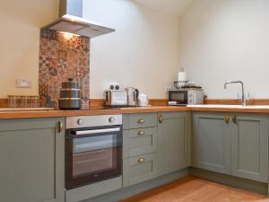 a kitchen with a sink and a stove top oven at The Loft - Uk50284 in Earl Sterndale