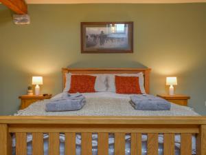 a bedroom with a bed with two pillows on it at The Loft - Uk50284 in Earl Sterndale +6 photos