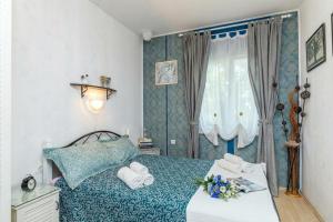 a bedroom with a bed with towels and a window at Cozy Home with Private Garden - Happy Rentals in Dražice