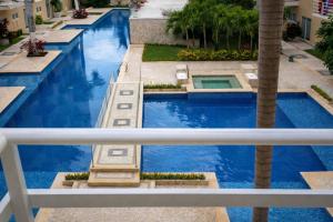 a view from a balcony of a pool with palm trees at Estudio compacto en Riviera Diamante con alberca in Acapulco