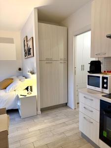 a bedroom with a bed and a kitchen with a microwave at Pieno Centro in Basiglio