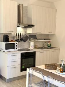 a kitchen with white cabinets and a stove top oven at Pieno Centro in Basiglio