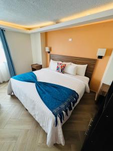 a bedroom with a large bed with a blue blanket at Suites del Jardín Principal in Guanajuato +63 photos