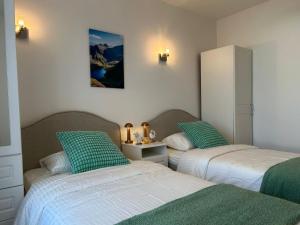 a bedroom with two beds with green and white sheets at Europe's last sunset in Waterville