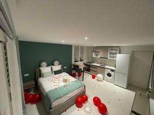 a bedroom with a bed and a kitchen with red balloons at Studio Élégance in Cayenne