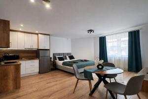 a bedroom with a bed and a kitchen with a table at Apartamenty Nad Pilicą - Klimatyzacja - Sulejów in Sulejów