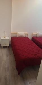 two beds in a room with a red comforter at Segredo do Lago in Monsaraz +3 photos