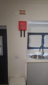 a kitchen with a sink and a sign on the wall at Segredo do Lago in Monsaraz