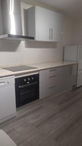 a kitchen with white cabinets and a black oven at Segredo do Lago in Monsaraz