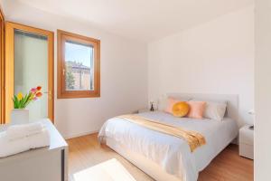 a white bedroom with a bed and a window at Apartment in Serravalle in Vittorio Veneto