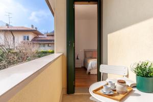 a balcony with a table with cups and a tray of food at Apartment in Serravalle in Vittorio Veneto