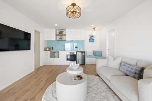 a living room with a white couch and a kitchen at Beachfront Studio - Ocean Views - Bell Block in New Plymouth