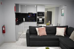 a living room with a couch and a kitchen at Pauloldtown - Local experience w rooftop n jacuzzi in Paul do Mar