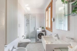 a white bathroom with a sink and a toilet at Apartment in Serravalle in Vittorio Veneto +20 photos