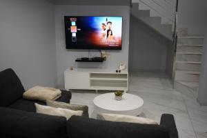 a living room with a couch and a flat screen tv at Pauloldtown - Local experience w rooftop n jacuzzi in Paul do Mar