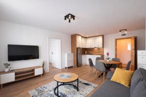 a living room with a couch and a table at Apartamenty Nad Pilicą - Klimatyzacja - Sulejów in Sulejów