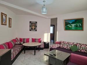 a living room with a couch and a table at RESIDENCE AL Hoceima 2 Minutes de prés de PLAGE CALABONITA in Al Hoceïma